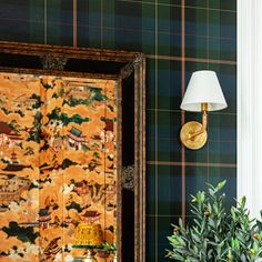 a green and yellow wallpaper with a lamp next to it on top of a table