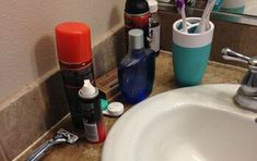 a bathroom sink with toothbrushes, shampoos and other personal care items