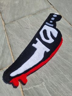 a black and red towel with the word i d on it sitting on top of a stone floor