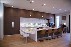 a large kitchen with wooden floors and white counter tops