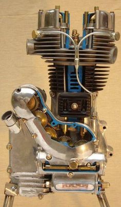 an old motorcycle engine is shown with blue and silver parts on it's side