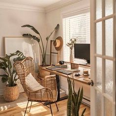 a room with a desk, chair and potted plants