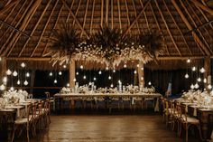 a large dining room with tables and chairs set up for a wedding reception at night