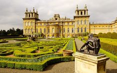 a statue is in the middle of a formal garden