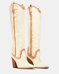 A Western boot is a requirement for any wardrobe and we’re obsessed with LASSO. This knee-high pair features whipstitching detail and a towering block heel. 3.75 inch heel height Size 6 measurements: 15 inch shaft circumference, 13.25 inch shaft height Size 8 measurements: 15.75 inch shaft circumference, 14.25 inch shaft height Size 10 measurements: 16.75 inch shaft circumference, 15 inch shaft height Textile upper material Textile and synthetic lining Synthetic sock Synthetic sole Imported Knee High Cowgirl Boots, High Cowgirl Boots, Denim Heels, Western Boot, Comfortable Heels, Dress Sandals, Cowgirl Boots, White Denim, Bridal Shoes