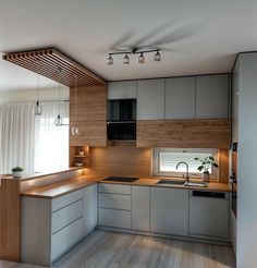 a modern kitchen with wood paneling and stainless steel appliances