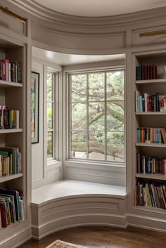 a curved window with bookshelves in the corner