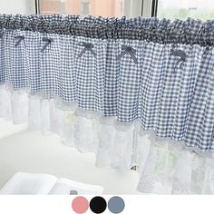 an open book sitting on top of a table next to a window with gingham curtains