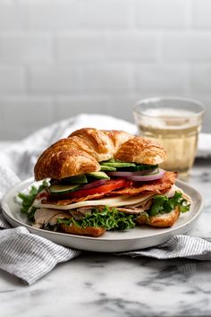 a sandwich with meat, lettuce and tomato on a plate