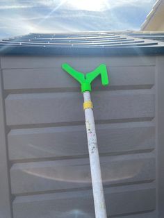 a green and white shovel sitting on top of a garage