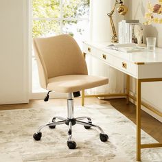 an office chair sitting on top of a rug in front of a desk with a window