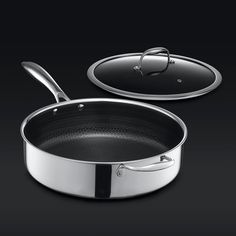 an empty pan with a lid and spoon on the side, next to it is a black background