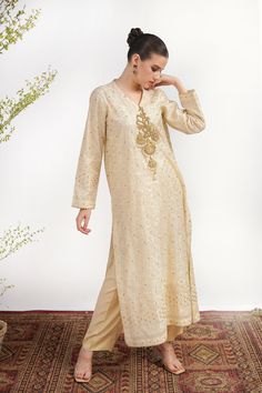 A white, Khadi Silk suit with machine net on the shirt and embroidery with kora, dabka, nakshi handwork. Paired with a silk trouser and Maisori net dupatta for a classy look. 3-piece suit Ready to wear Semi-stitched Gold Kurta With Naqshi, Semi-stitched Cream Kurta With Zari Work, Festive Chanderi Kurta With Naqshi Detail, Off White Raw Silk Designer Wear Sets, Off White Raw Silk Designer Sets, Festive Naqshi Chanderi Kurta, Off White Raw Silk Sets For Designer Wear, Festive Naqshi Raw Silk Sets, Elegant Off White Raw Silk Sets