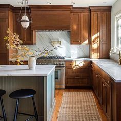 a kitchen with wooden cabinets and marble counter tops