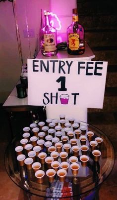 there is a sign that says entry fee 1 shot on the table with cups in front of it