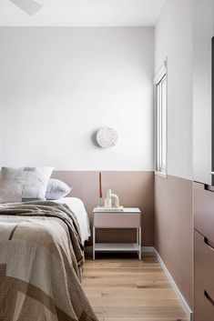 a bedroom with white walls and wood floors