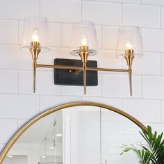 a bathroom light with three lights on the wall above it and a mirror in front of it