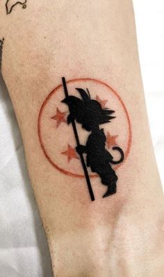 a person with a tattoo on their arm holding a stick and arrow in the shape of a mouse