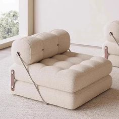 two white chairs sitting on top of a carpeted floor next to a large window