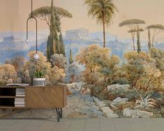 a wall mural with trees and plants on it in front of a table next to a cabinet