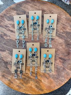 "Here are our punchy turquoise western stone earrings. Choose from 5 different designs: YeeHaw, Cowgirl, Rodeo Queen, Honky Tonk or Y'all.  The letters are stamped with tiny cacti, arrows and more. Certain designs come with additional cute charms.  Made with natural stone set in a burnished silver tone setting. These make a great gift for that Western jewelry lovin family or friend in your life! Measurements:  Width on all is 1 inch Length: Cowgirl- 3.25\" Honky Tonk- 3.75\" Rodeo Queen- 4\" Y'a Cowgirl Earrings, Rodeo Jewelry, Turquoise Stone Earrings, Western Turquoise, Engraving Ideas, Turquoise Western, Cowgirl Rodeo, Rodeo Queen, Hippy Gifts