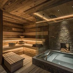 an indoor sauna with stone walls and wood flooring is lit up by lights