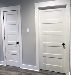 an empty room with three white doors in it