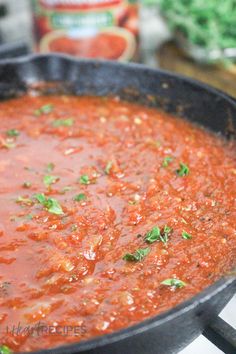 a skillet filled with tomato sauce on top of a stove