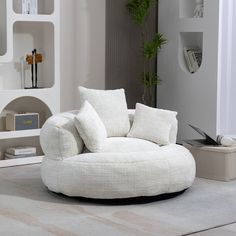 a living room with a white chair and some books on the shelf above it is a plant