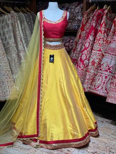 Tuscany yellow plain lehenga with broad gotta patti border teamed with contrasting red blouse and net dupatta. Fabric: Raw Silk This outfit can be customized in multiple colors and specific to client measurements. 90 days of production time is required and are for bulk orders only! Orders are processed in store only! Final fittings/alterations not included. Minimum Order Quantity- 4 pieces Red Yellow Lehenga, Lemon Yellow Lehenga Color Combos, Yellow Dola Silk Choli With Sheer Dupatta, Yellow Choli With Sheer Dupatta In Dola Silk, Bollywood Style Yellow Gown With Cutdana, Yellow Raw Silk Lehenga With Pallu, Yellow Raw Silk Lehenga With Pallu Detail, Fitted Yellow Raw Silk Lehenga, Yellow Gown With Pallu For Navratri