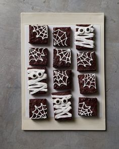 halloween brownies decorated with white icing and spooky eyes on a plate