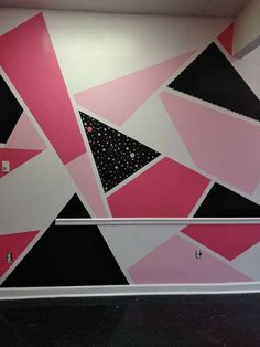 the wall is decorated with pink and black triangles