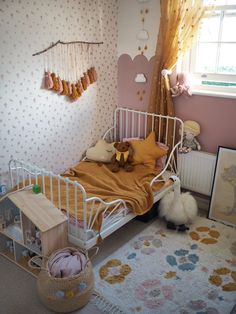 a small child's bedroom with pink walls and floral wallpaper on the walls