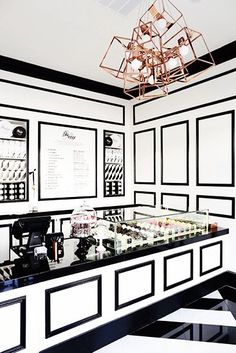 a room with black and white walls, a chandelier and pictures on the wall