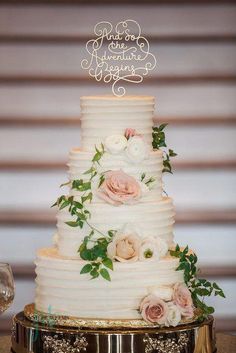 a three tiered wedding cake with flowers on top