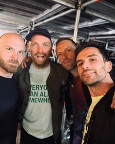 four men are posing for a photo together