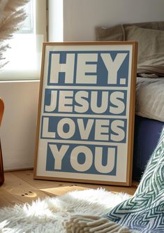 a blue and white poster with the words hey jesus loves you on it next to a chair