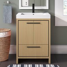 a white sink sitting under a bathroom mirror next to a wooden cabinet with drawers on it