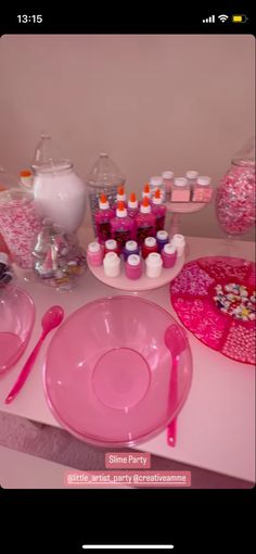 the table is set with pink dishes and utensils