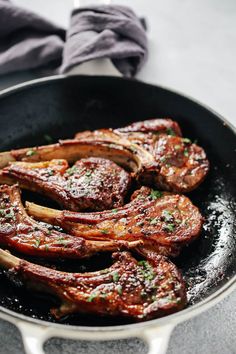 steaks are cooking in a skillet on the stove