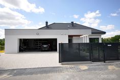 a car is parked in front of a house that has a driveway and fence around it