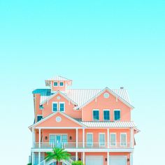 an orange and white house with palm trees in the foreground