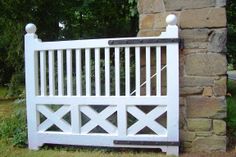 a white wooden bench sitting next to a stone wall