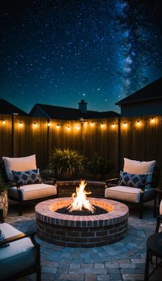 an outdoor fire pit surrounded by chairs and lights under the night sky with stars in the background