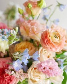 a vase filled with lots of different colored flowers