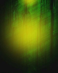 a yellow light shining on the side of a wooden wall with green and black paint