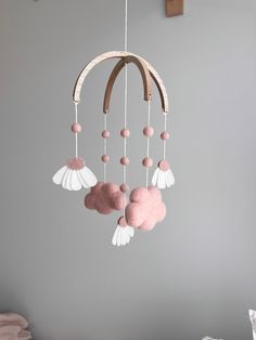 a pink and white mobile hanging from the ceiling in a child's nursery room