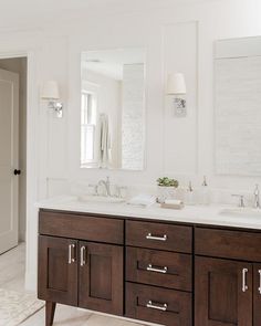 a bathroom with double sinks and two mirrors on the wall next to eachother