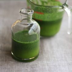 two small glass bottles filled with green liquid