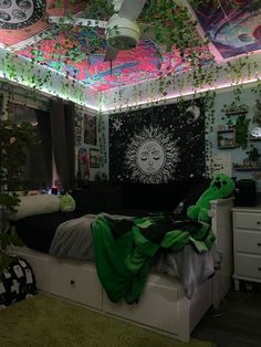 a bedroom decorated in green and white with lots of plants on the ceiling, lights above the bed